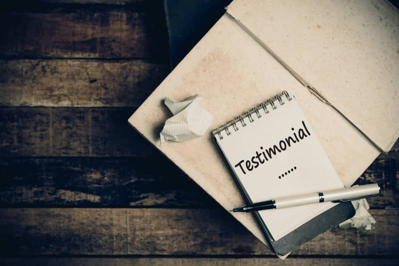 Testimonial Word on Sketch Book on Wood Table