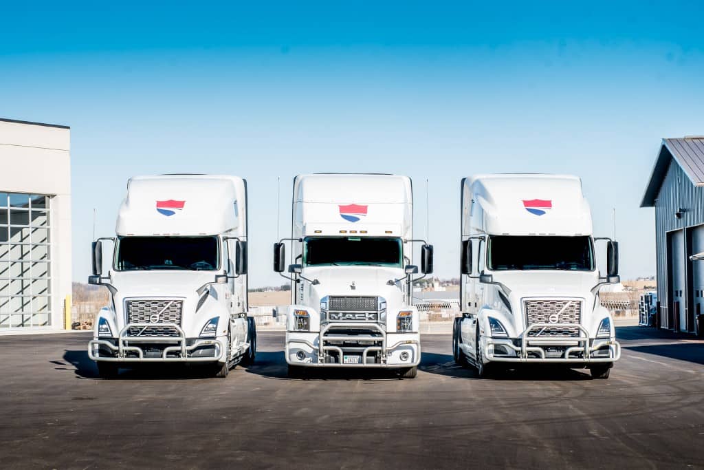 Three Wellington Group of Companies Transport Trucks parked and facing the camera front on.